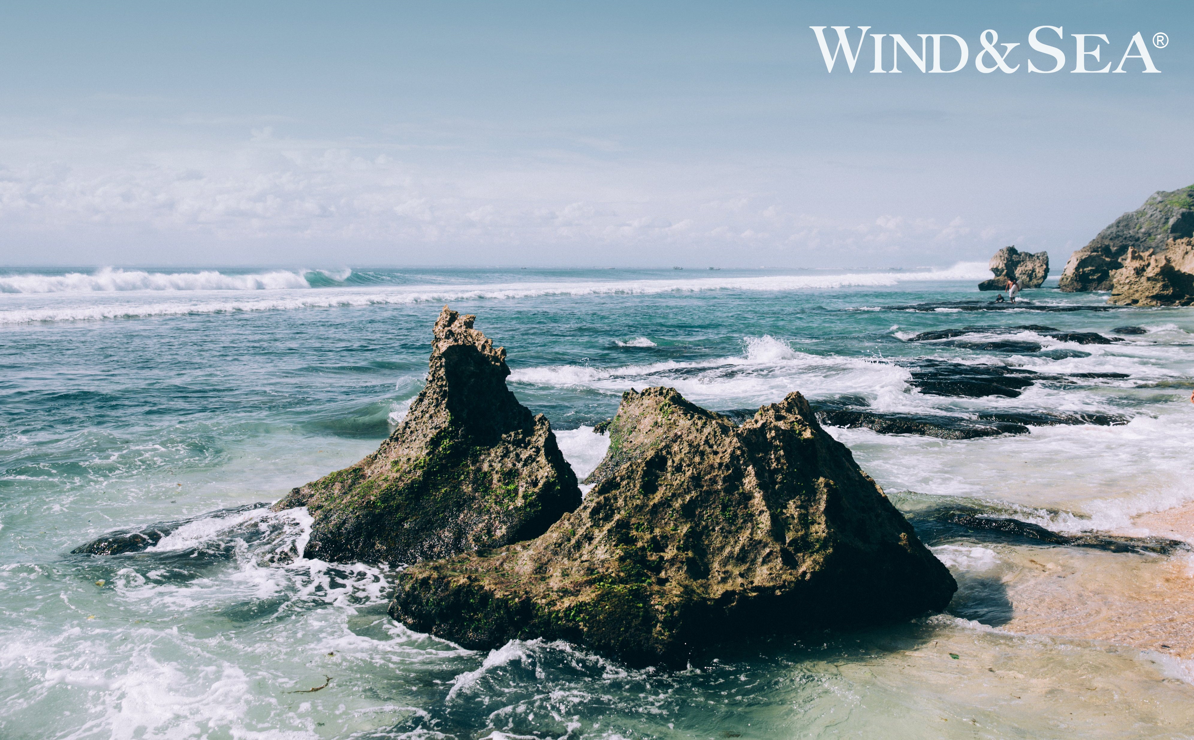 Image of a rock in the ocean with waves inthe background